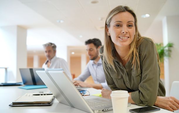 startup woman entrepreneur looking straight while people work in the background